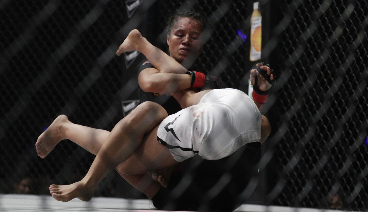 Petarung Indonesia, Priscilla Lumban Gaol, mengunci petarung India, Puja Tomar, saat bertarung pada laga ONE Championship di Istora Senayan, Jakarta, Sabtu (19/1). Priscilla kalah dari Puja. (Bola.com/M. Iqbal Ichsan)