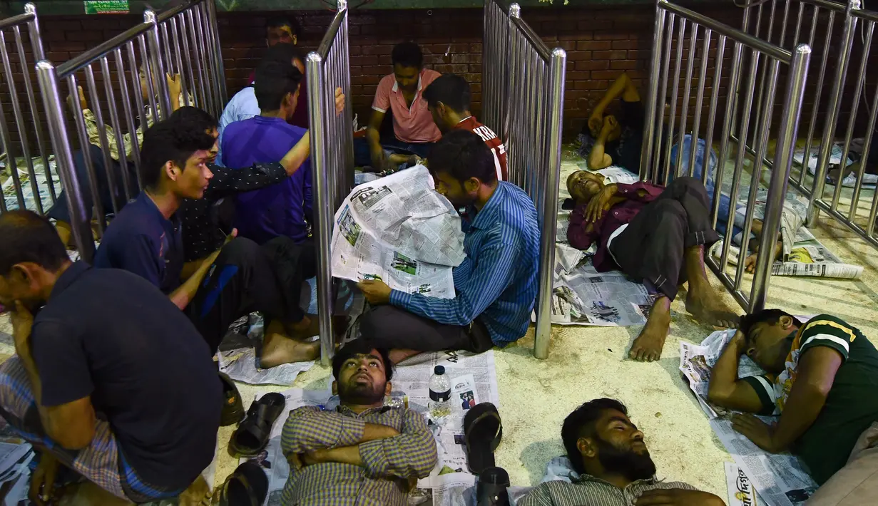 Sejumlah calon pembeli duduk dan tidur di depan loket untuk mendapatkan tiket mudik lebaran di Stasiun Kereta Kamalapur, Dhaka, Minggu (3/7). Perayaan Idul FItri merupakan salah satu tradisi yang terbesar di Bangladesh. (AFP PHOTO/MUNIR UZ ZAMAN)