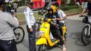 Petugas Dishub mensosialisasikan kepada pengendara sepeda motor listrik Migo saat melintasi CFD di kawasan Bundaran HI, Jakarta, Minggu (17/2). Penyewa sepeda motor listrik dihimbau untuk tidak melintasi jalan raya. (Liputan6.com/Faizal Fanani)