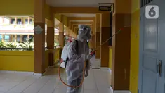 Petugas PMI menyemprotkan cairan disinfektan di Lingkungan SMP Negeri 139 Jakarta, Selasa (9/6/2020). Penyemprotan untuk mencegah penyebaran virus Corona di lingkungan sekolah itu sebagai persiapan memasuki tahun ajaran baru 2020/2021. (merdeka.com/Imam Buhori)