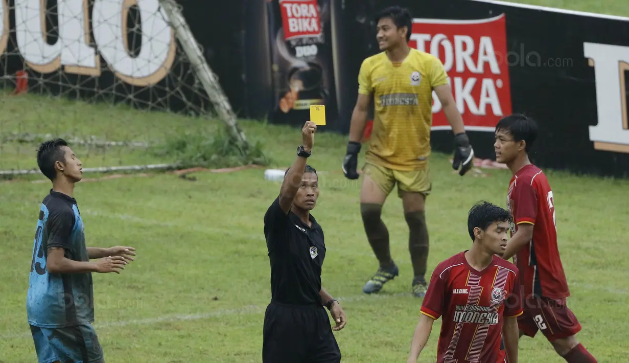 Wasit Bangil Saputra, memberikan kartu kuning kepada pemain UPI pada laga final Torabika Campus Cup 2017 di Stadion Cakrawala, Malang, Kamis (23/11/2017). UMM menang WO atas UPI. (Bola.com/M Iqbal Ichsan)