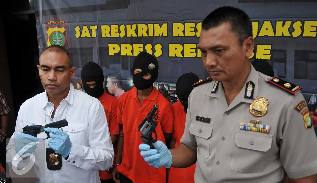 Kasat Reskrim Polres Metro Jakarta Selatan AKBP Audie Latuheru (kiri) menunjukkan barang bukti senjata api saat rilis kasus pencurian dengan kekerasan,di Jakarta, Rabu (25/11). Polisi berhasil mengamankan empat pelaku. (Liputan6.com/Gempur M Surya)