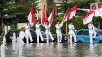 Sejumlah pasukan pengibar bendera (Paskibra) berbaris membawa bendera Merah Putih di Bundaran Hotel Indonesia (HI), Jakarta, Kamis (15/8/2024). (Liputan6.com/Herman Zakharia)