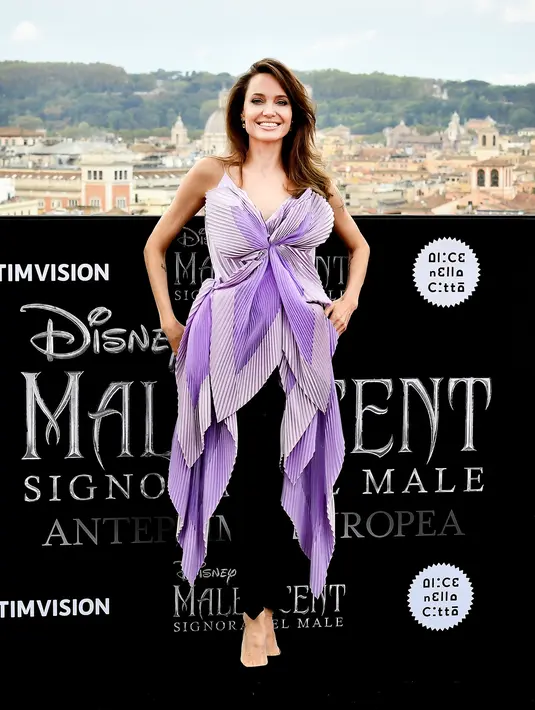 Aktris AS Angelina Jolie berpose saat sesi pemotretan untuk pemutaran perdana film Disney "Maleficent: Mistress of Evil" di Roma, Italia (7/10/2019). Angelina Jolie tampil cantik mengenakan gaun ungu dengan celana dan sepatu hitam. (AFP Photo/Tiziana Fabi)