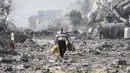 <p>Kehancuran terlihat jelas di seluruh Gaza, ketika warga Palestina mati-matian mencari korban yang selamat dan terpaksa berjalan melewati puing-puing yang tertinggal setelah pemboman Israel. (AP Photo/Ali Mahmoud)</p>