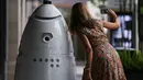 Seorang wanita berswafoto bersama robot keamanan baru yang bernama ROD2 di River Oaks District, Houston (18/8). Robot baru ini menjadi tambahan untuk tim pengaman dan patroli rutin di River Oaks District. (Michael Ciaglo / Houston Chronicle via AP)