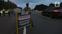 Petugas dari Polres Bogor memasang rambu penutupan jalan di pintu keluar Tol Gadog, Bogor, Sabtu (31/12/2022). Penutupan jalan jalur Puncak Bogor untuk gelaran Car Free Night dimulai sejak pukul 18.00 WIBdan dibuka kembali esok pagi pukul 06.00 WIB. (merdeka.com/Arie Basuki)