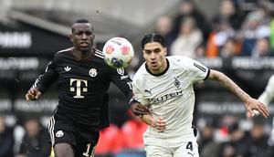 Bek Borussia Monchengladbach Kevin Diks menjaga dengan ketat striker Bayern Munchen, Nicolas Jackson dalam laga Bundesliga 2025/2026 di Borussia Park, Sabtu (25/10/2025) malam WIB. (AFP/Ina Fassbender)