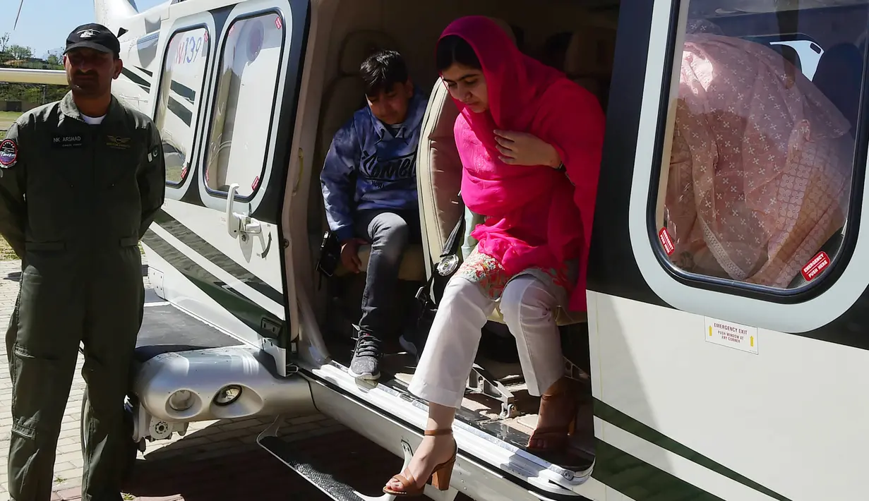 Aktivis Pakistan dan penerima Nobel Perdamaian Malala Yousafzai turun dari helikopter saat tiba di Kota Swat, Pakistan (31/3). Helikopter, yang membawa Malala, mendarat tidak jauh dari rumah keluarganya di Mingora. (AFP Photo/Abdul Majeed)