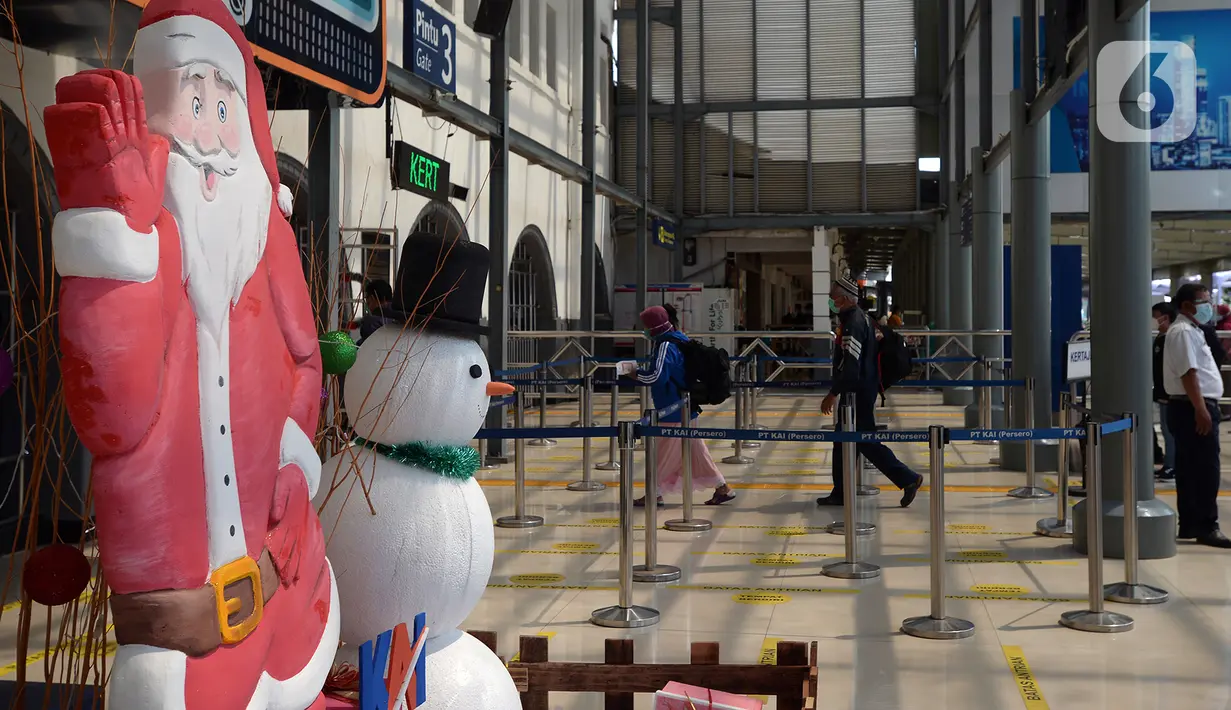 Dekorasi Natal menghiasi Stasiun Senen, Jakarta, Jumat (25/12/2020). Petugas KAI yang mengenakan kostum Natal membagikan masker kepada calon penumpang untuk memutus mata rantai penyebaran COVID-19 saat mudik Natal dan Tahun Baru 2021. (merdeka.com/Imam Buhori)