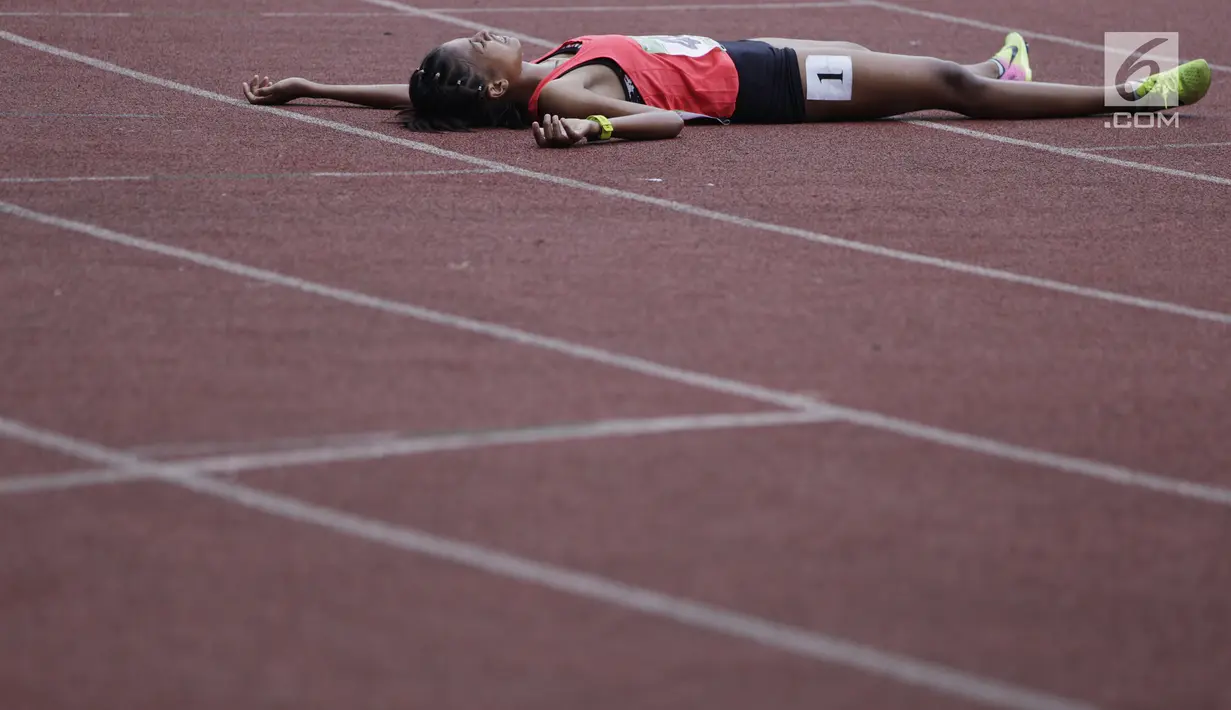 Pelari Jawa Timur, Mila Karmila, tampak lelah usai tampil pada Kejurnas Atletik 2019 nomor 3.000 meter steeplechase U-20 putri di Stadion Pakansari, Bogor pada Rabu (8/8/2019). Kejurnas Atletik berlangsung dari 3 hingga 7 Agustus. (Bola.com/Vitalis Yogi Trisna)