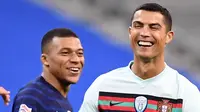 Striker Portugal, Cristiano Ronaldo, tertawa bersama striker Prancis, Kylian Mbappe, pada laga UEFA Nations League di Stadion Stade de France, Senin (12/10/2020). Kedua tim bermain imbang 0-0. (AFP/Franck Fife)