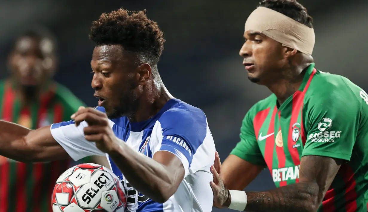 Striker FC Porto, Ze Luis, berebut bola dengan bek Maritimo, Rene Santos, pada laga lanjutan Liga Portugal di Dragao Stadium, Porto, Kamis (10/6/2020) waktu setempat. Porto menang tipis 1-0 atas Maritimo. (AFP/Jose Coelho/Pool)