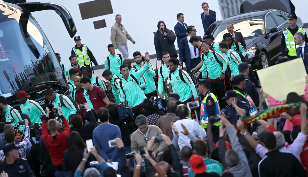 Cristiano Ronaldo menyapa penggemarnya saat akan meninggalkan bandara Medeira, Portugal (27/3). Timnas sepak bola Portugal akan memainkan laga di tanah kelahiran Ronaldo di Madeira. (AP Photo/Armando Franca)