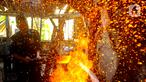 Perajin menempa logam besi saat membuat pisau khusus sembelih hewan kurban di Bengkel Tempa dan Asah Bilah HM, Jalan Akasia, Pamulang Timur, Tangerang selatan, Kamis (13/6/2024). (merdeka.com/Arie Basuki)