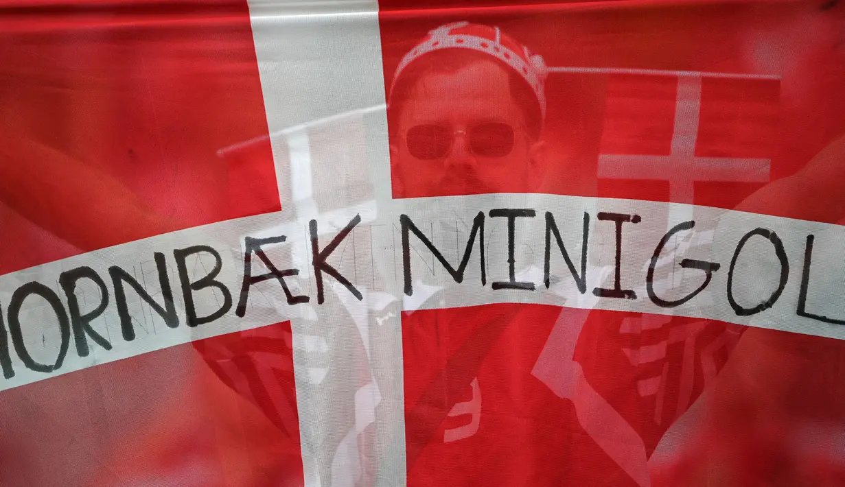 Seorang pendukung Denmark memegang bendera nasional selama pertandingan sepak bola perempat final UEFA EURO 2020 antara Republik Ceko dan Denmark di Stadion Olimpiade di Baku pada 3 Juli 2021. (AFP/Pool/Ozan Kose)