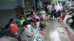 Warga yang rumahnya terendam banjir mengungsi di Gedung SMP Negeri 26, Jalan Kebon Pala, Kampung Melayu, Jatinegara, Jakarta Timur, Selasa (6/2). Sekolah masih tetap masuk, tetapi hanya diabsen karena tidak adanya listrik. (Liputan6.com/Arya Manggala)