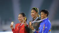 Diketahui, Emilia Nova terakhir kali meraih emas heptathlon pada 2017. Tampak dalam foto, atlet atletik Indonesia, Emilia Nova (tengah) usai prosesi pengalungan medali usai memenangi lomba dan meraih emas nomor heptathlon (tujuh lomba) SEA Games 2025 di Stadion Supachalasai Bangkok, Thailand Selasa (16/12/2025) malam. (Bola.com/Bagaskara Lazuardi)