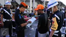 Petugas mengecek kecocokan data karcis dengan identitas pemudik di Stasiun Senen Jakarta, Sabtu (2/7). Ribuan pemudik kembali memadati Stasiun Senen untuk berangkat menuju kota kota di pulau Jawa. (Liputan6.com/Helmi Fithriansyah)