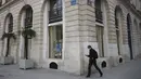 Seorang pria berjalan di depan toko Louis Vuitton yang tutup di Paris (22/3/2021).Sementara pemerintah Prancis bersikeras bahwa aturan tersebut tidak akan seketat di masa lalu, tindakan tersebut dikritik karena dianggap berantakan. (AP Photo/Lewis Joly)