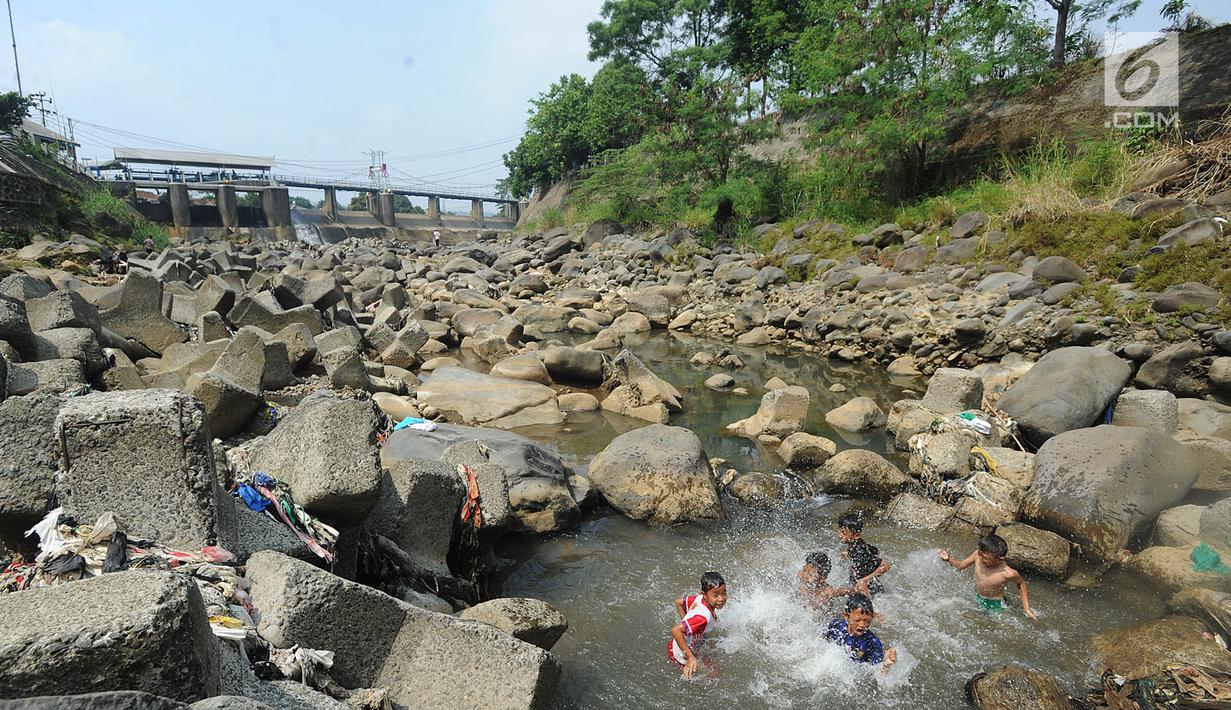 Anak-anak bermain pada kubangan air yang tersisa di kawasan Bendungan Katulampa, Bogor (15/7). Musim kemarau menyebabkan Bendungan Katulampa berada di titik nol berdampak pada sumur-sumur warga di sekitar mengalami kekeringan. (Merdeka.com/Arie Basuki)