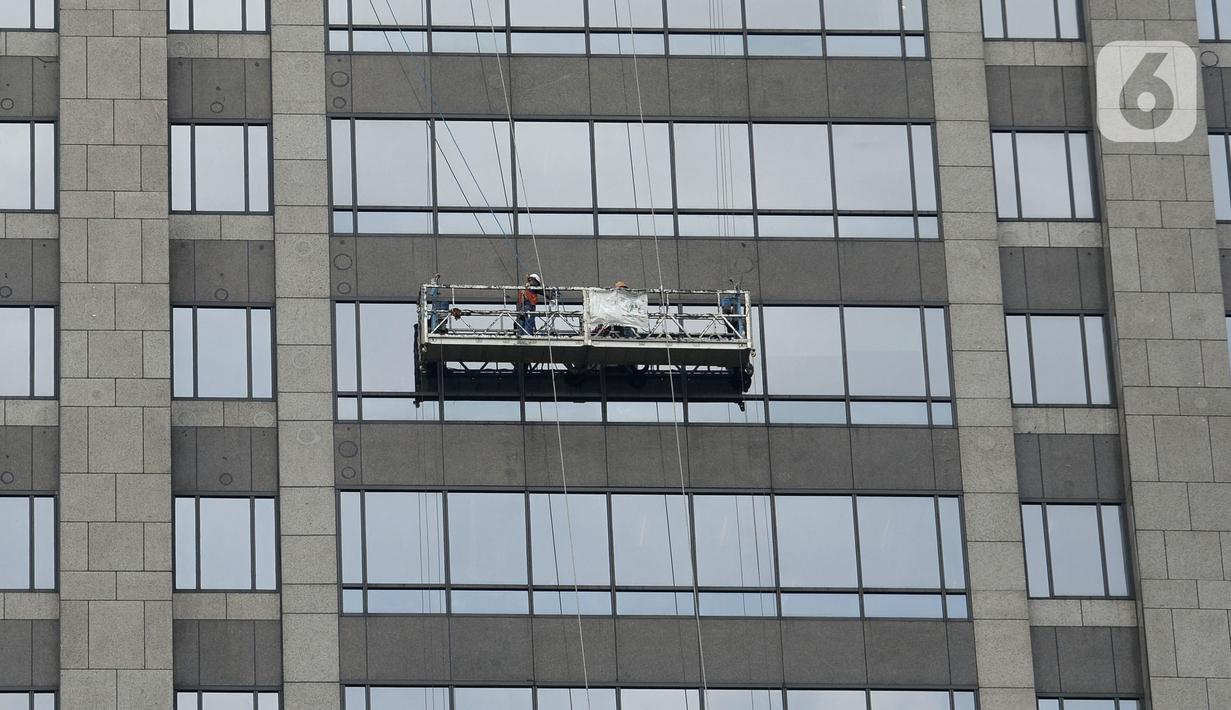 Pekerja membersihkan kaca gedung bertingkat di kawasan Sudirman Central Business District (SCBD), Jakarta, Senin (8/6/2020). Hampir tiga bulan kebijakan work from home (WFH) akibat pandemi COVID-19, banyak gedung bertingkat tidak terawat hari ini mulai dibersihkan. (merdeka.com/Dwi Narwoko)
