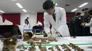 Petugas mengumpulkan sisa kerangka tentara China untuk dimasukkan ke dalam peti mati di osuarium militer, Incheon, Seoul, Senin (26/3). Kerangka-kerangka itu tengah diidentifikasi sebelum ditempatkan pada Osuarium Militer. (Jung Yeon-je/Pool Photo via AP)