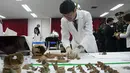 Petugas mengumpulkan sisa kerangka tentara China untuk dimasukkan ke dalam peti mati di osuarium militer, Incheon, Seoul, Senin (26/3). Kerangka-kerangka itu tengah diidentifikasi sebelum ditempatkan pada Osuarium Militer. (Jung Yeon-je/Pool Photo via AP)