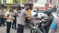 Wakapolres Garut Kompol Yopy M. Suryawibawa, bersama para anggota Polres Garut tengah membagikan paket takjil gratis bagi pengguna jalan, Senin (4/4/2022) petang. (Liputan6.com/Jayadi Supriadin)