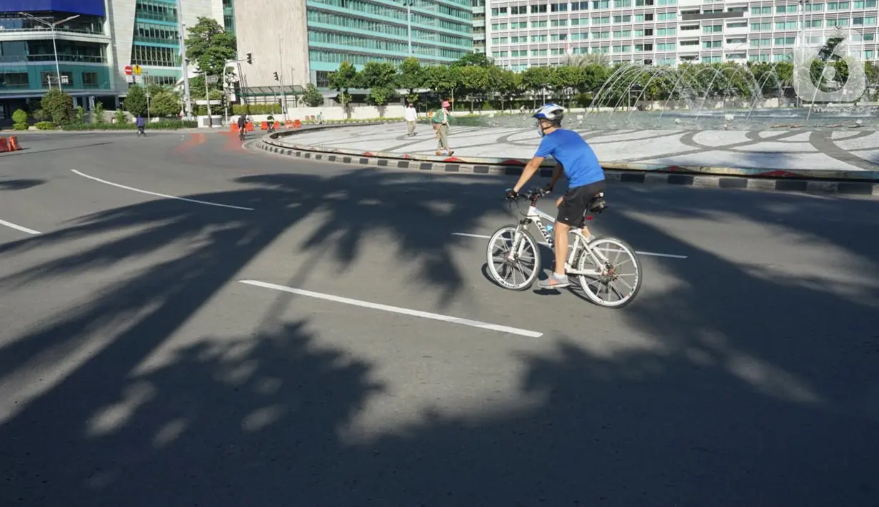 Pesepeda melintas di kawasan Bundaran HI, Jakarta, Minggu (24/5/2020). Adanya PSBB serta Hari Raya Idul Fitri 1441 H dimanfaatkan sebagian warga untuk bersepeda di jalan protokol yang sepi dibanding hari biasa. (Liputan6.com/Immanuel Antonius)