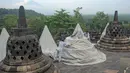 Pekerja menutup stupa di kompleks candi Borobudur, Magelang, Jawa Tengah, Senin (23/11/2020). Penutupan candi Borobudur oleh BKB (Balai Konservasi Borobudur) sebagai langkah antisipasi melindungi batu candi dari abu vulkanik jika Gunung Merapi erupsi. (Photo by Agung Supriyanto/AFP)