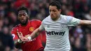 Striker West Ham United, Javier Hernandez berusaha menggiring bola dari kejaran gelandang Manchester United, Fred selama pertandingan lanjutan Liga Inggris di Old Trafford (13/4). MU menang tipis atas West Ham 2-1. (AFP Photo/Paul Ellis)