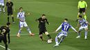 Penyerang Barcelona, Lionel Messi berusaha melewati pemain Real Sociedad, Martin Merquelanz pada pertandingan La Liga Spanyol di stadion Reale Arena, Spanyol (22/3/2021).Barcelona tertinggal empat poin dari Atletico Madrid (66) yang menempati posisi puncak klasemen. (AP Photo/Alvaro Barrientos)