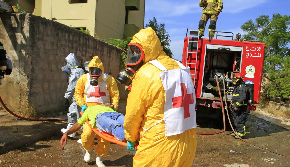 Anggota pertahanan sipil membawa warga saat mengambil bagian dalam latihan simulasi serangan senjata kimia di kota Kfar Falous (8/10/2019). (AFP Photo/Mahmoud Zayyat)