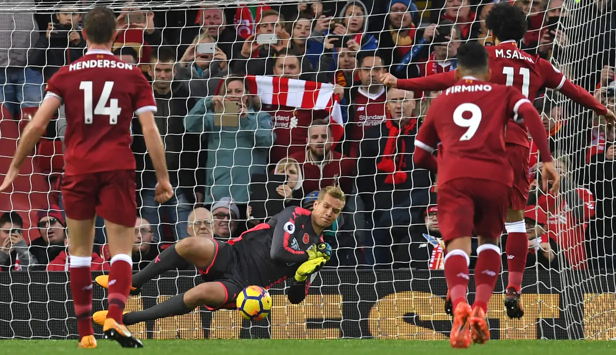 Kiper Huddersfield Town, Jonas Lossl (tengah) menghalau sepakan pemain Liverpool, Mohamed Salah pada lanjutan Premier League di Stadion Anfield, Liverpool, (28/10/2017). Liverpool menang 3-0. (AFP/Paul Ellis)