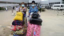 Penumpang menggunakan masker dan sarung tangan saat tiba di Bandara Murtala Mohammed, Lagos, 11 Agustus 2014. Nigeria mengkonfirmasi kasus baru Ebola yang ditemukan di Lagos. (AFP PHOTO/PIUS UTOMI EKPEI)