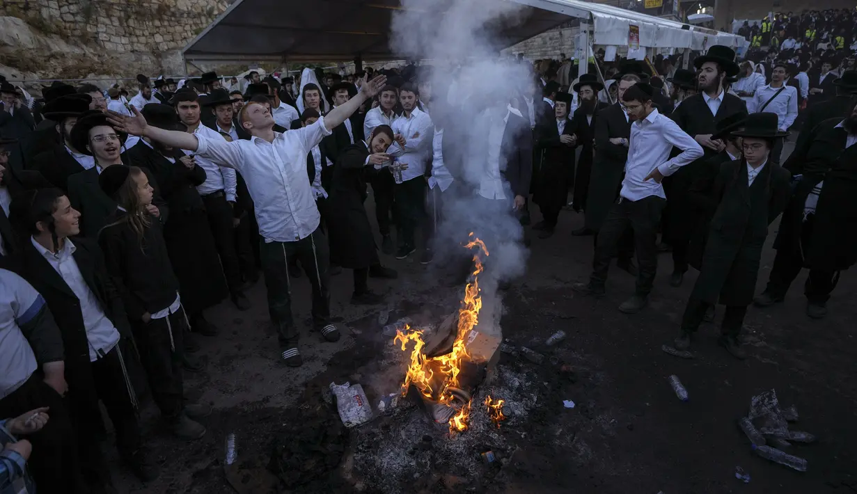 Orang-orang Yahudi Ultra Ortodoks menari di sekitar api unggun saat perayaan Lag BaOmer di situs makam tradisional Rabbi Shimon Bar Yochai di Gunung Meron, Israel, Kamis (19/5/2022). Orang Israel menyalakan api unggun selama perayaan Lag BaOmer untuk memperingati berakhirnya wabah yang dikatakan telah memusnahkan orang Yahudi di zaman Romawi. (AP Photo/Ariel Schalit)