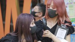 Sejumlah memakai masker wajah untuk membantu melindungi dari penyebaran coronavirus memegang kipas angin portabel untuk menghindari panas di Tokyo, Rabu, (5/8/2020). (AP Photo/Koji Sasahara)