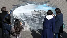 Sejumlah warga melihat sebuah karya ilusi optik 3-D yang bergambar kota Aleppo yang hancur akibat perang di kampus Universitas Meiji di Tokyo, Jepang (18/11). Karya ini ditampilkan untuk menimbulkan rasa kemanusiaan di Jepang. (AFP/Toshifumi Kitamura)