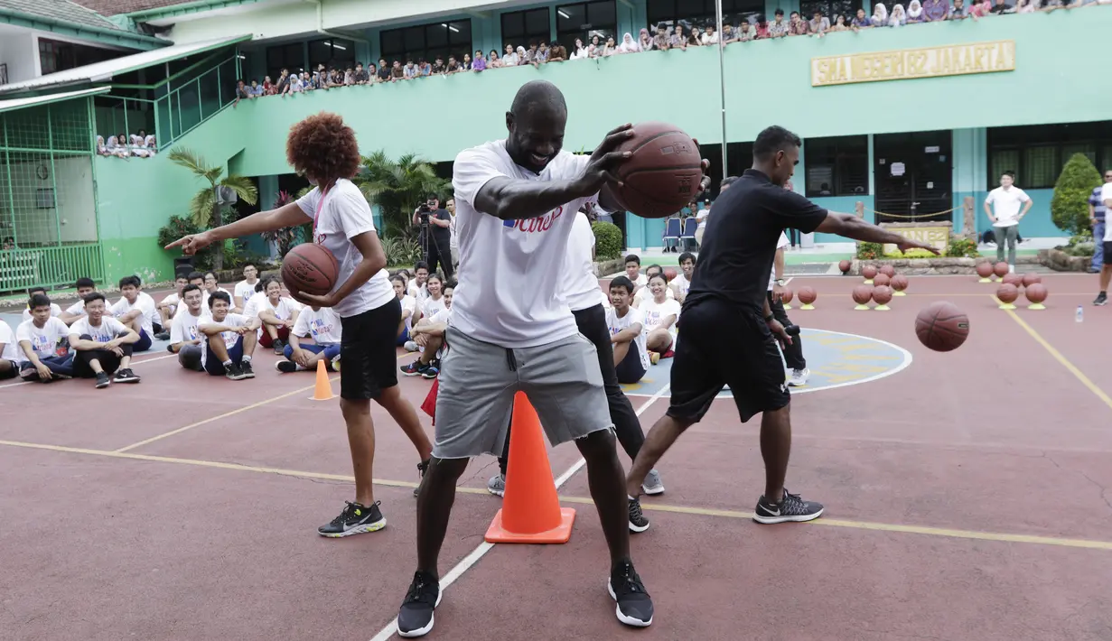 Legenda NBA, Jason Richardson, memberikan pelatihan kepada siswa SMA 82 Jakarta, Kamis (28/3). Kunjungan peraih dua gelar juara kontes slamdunk NBA tersebut merupakan bagian dari rangkaian program Jr NBA. (Bola.com/M Iqbal Ichsan)