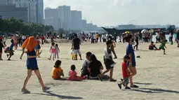 Orang-orang menikmati suasana Manila baywalk dolomite beach di sepanjang boulevard Roxas, kota Manila, Filipina pada Minggu (17/10/2021). Sehari sebelumnya, pihak berwenang melonggarkan pembatasan karantina di ibu kota negara itu. (Ted ALJIBE / AFP)
