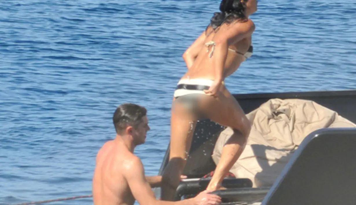 Zac Efron dan Michelle Rodriguez  menaiki tangga usai menyeburkan diri ke pantai, Pulau Sardinia, Italia, Selasa (8/7/2014) (mzn.com)