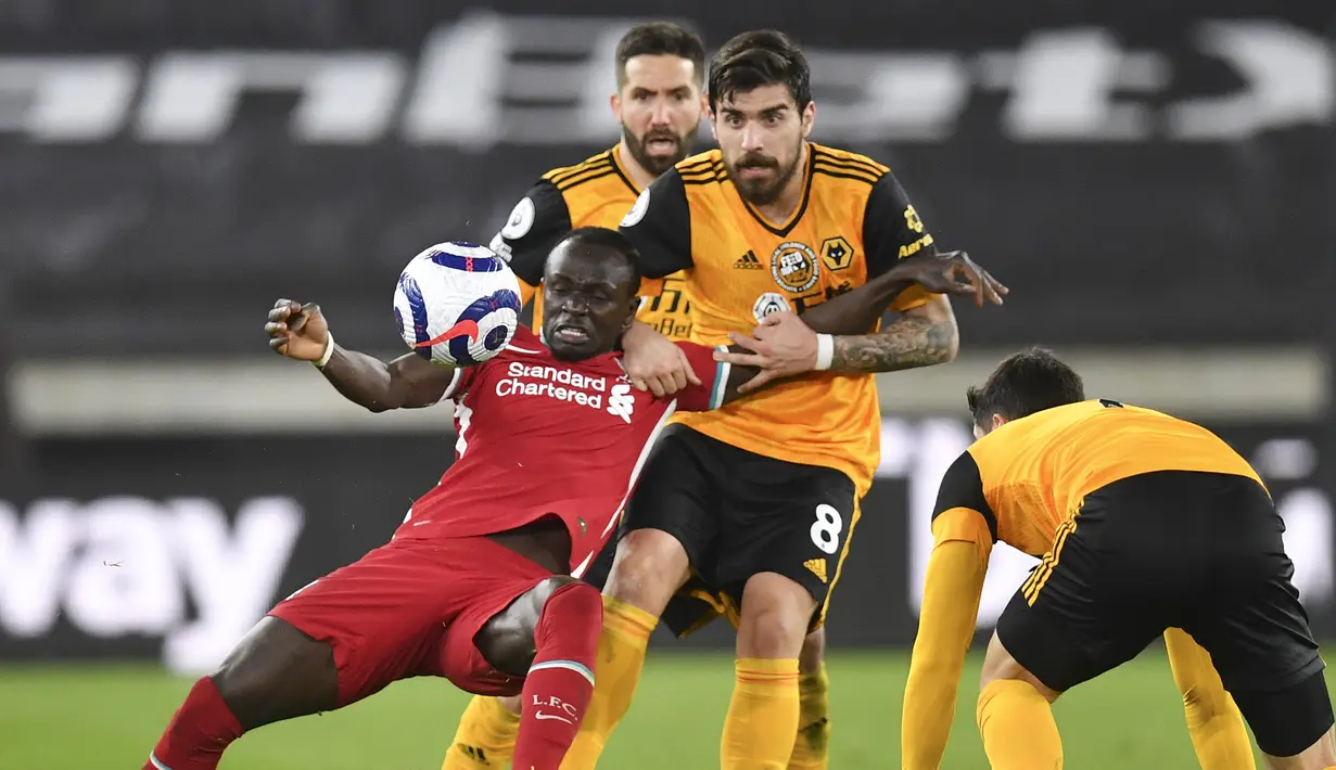 Striker Liverpool, Sadio Mane (kiri) berebut bola dengan gelandang Wolverhampton Wanderers, Ruben Neves dalam laga lanjutan Liga Inggris 2020/2021 pekan ke-28 di Molineux Stadium, Senin (15/3/2021). Liverpool menang 1-0 atas Wolverhampton. (AP/Paul Ellis/Pool)
