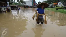Warga membawa jaring untuk mencari ikan saat banjir di jalan Merpati Raya kota,Tangerang Selatan, Selasa (21/2). Intensitas curah hujan yang tinggi di sertai buruknya Drainase menyebabkan banjir 50-100 cm di kawasan tersebut. (Liputan6.com/Helmi Afandi)