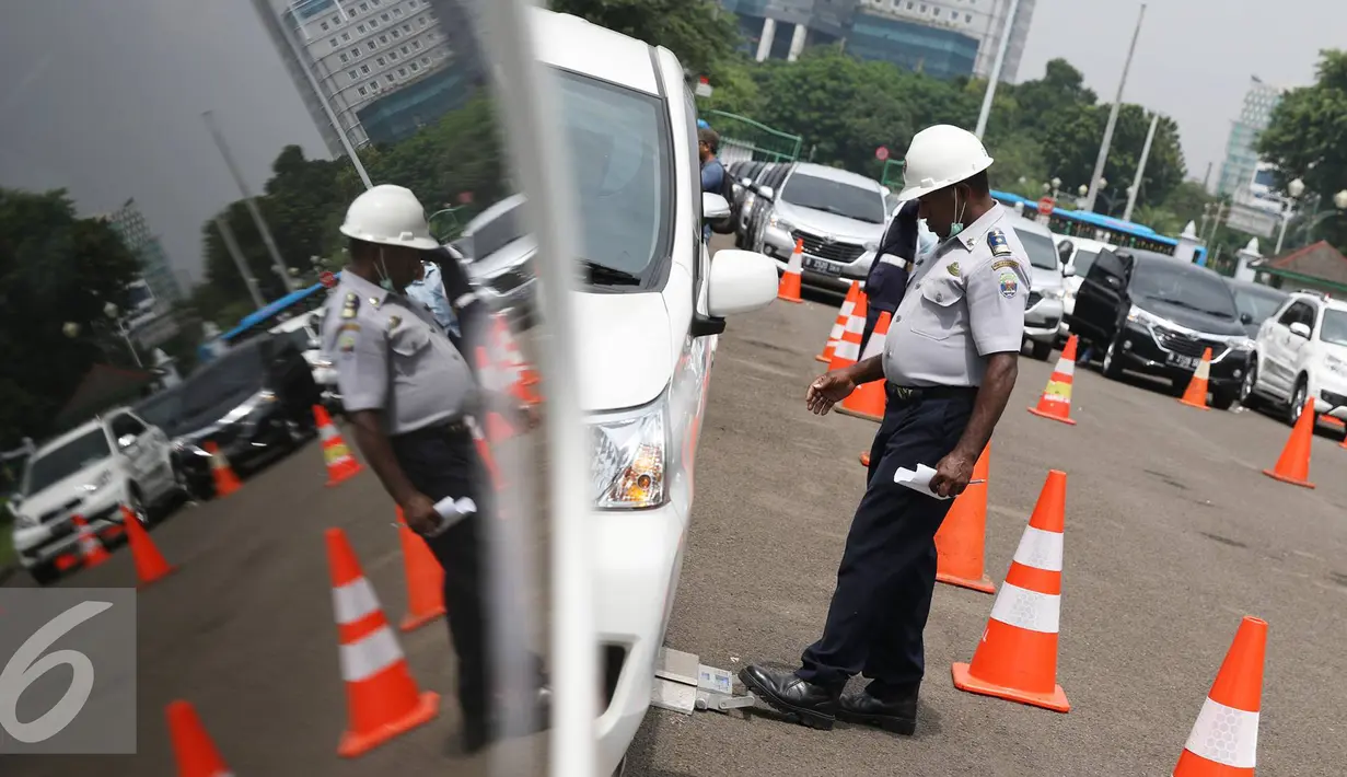 Petugas mengecek mobil peserta tes uji SIM dan kir transportasi online di Jakarta, (15/8). Kegiatan diadakan menyambut HUT Kemerdekaan RI ke-71 serta menciptakan layanan angkutan umum yang prima dan accountable. (Liputan6.com/Immanuel Antonius)