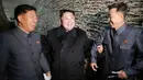 Pemimpin Korea Utara, Kim Jong-un (tengah) berbincang dengan pejabat yang mendampinginya saat mengunjungi stasiun perikanan di Pyongyang, Kamis (17/11). Kim Jong-un mengaku senang dengan hasil tangkapan ikan yang melimpah. (REUTERS/KCNA)
