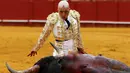 Matador Spanyol, Javier Castano berlumuran darah saat adu banteng di arena The Maestranza, ibukota Andalusia, Seville, (17/4). Javier Castano berlumuran darah setalah menusukkan pedang kedalam tubuh bantengnya. (REUTERS / Marcelo del Pozo)