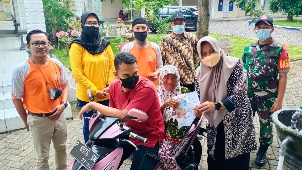 Kepala Dinas Sosial Banyuwangi Heni Setiorini   menyerahkan bansos sembako Rp 600 ribu ke warga. (Istimewa)