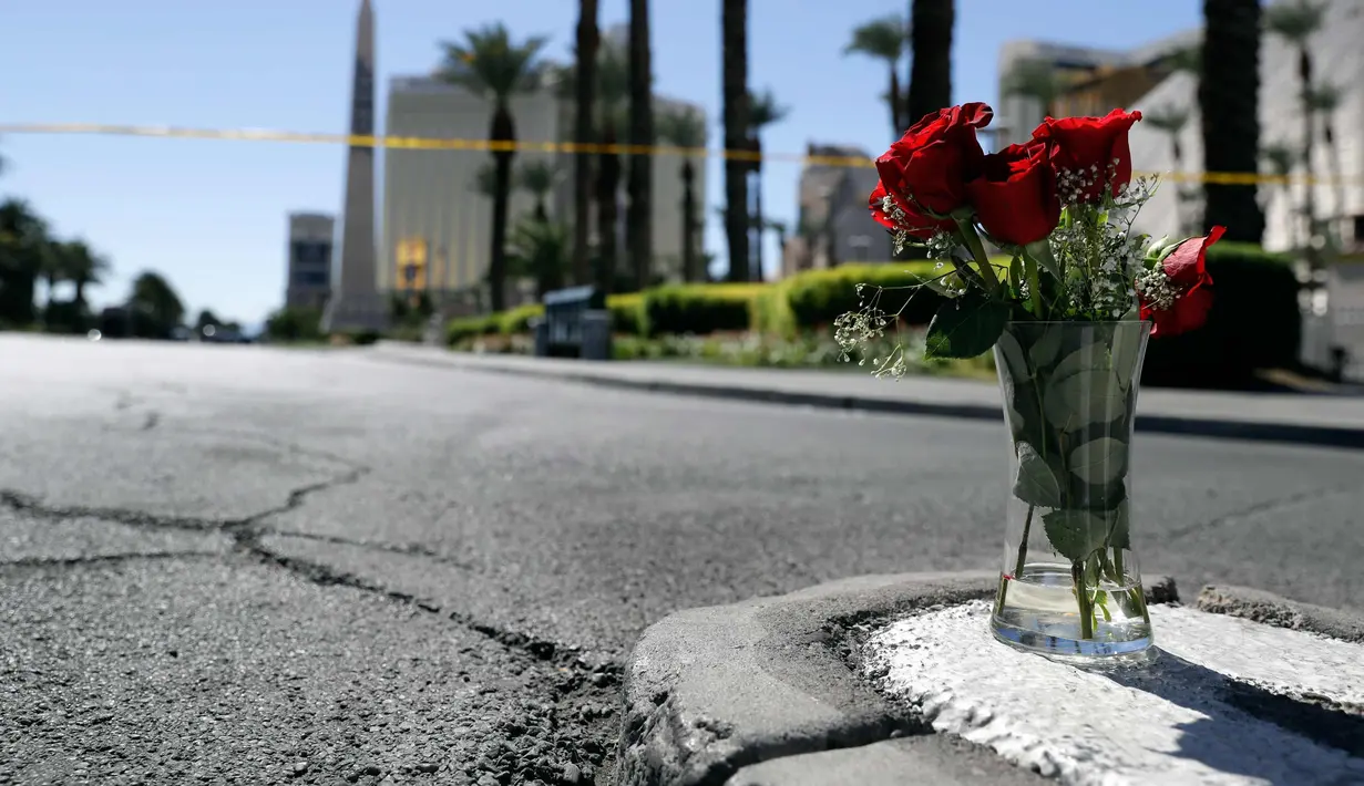 Bunga mawar merah terlihat di lokasi penembakan massal di festival musik di dekat resor dan kasino Mandalay Bay di Las Vegas (2/10). Bunga tersebut untuk korban penembakan Las Vegas yang dilakukan Stephen Paddock 64 tahun. (AP Photo/Marcio Jose Sanchez)