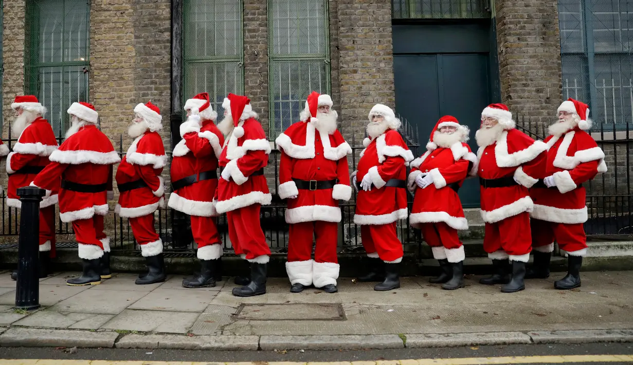 Sejumlah pria mengenakan kostum Santa Claus berbaris saat sesi pemotretan di Ragged School Museum di London (16/11). Sekolah ini juga mengajarkan teknik mengembus serta tertawa ho ho ho khas Santa Claus. (AP Photo/Matt Dunham)